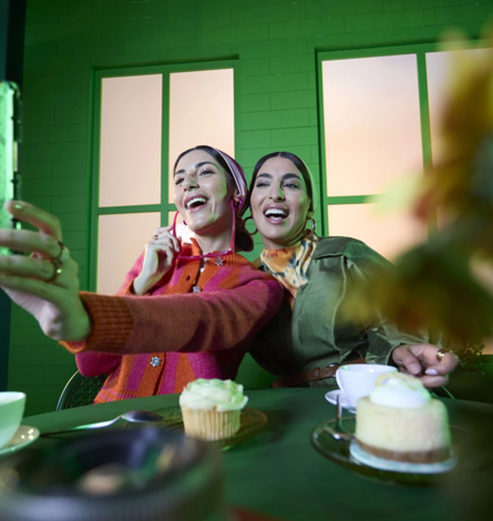 Two women filming themselves abroad on their phones using a Salam eSIM roaming data pack