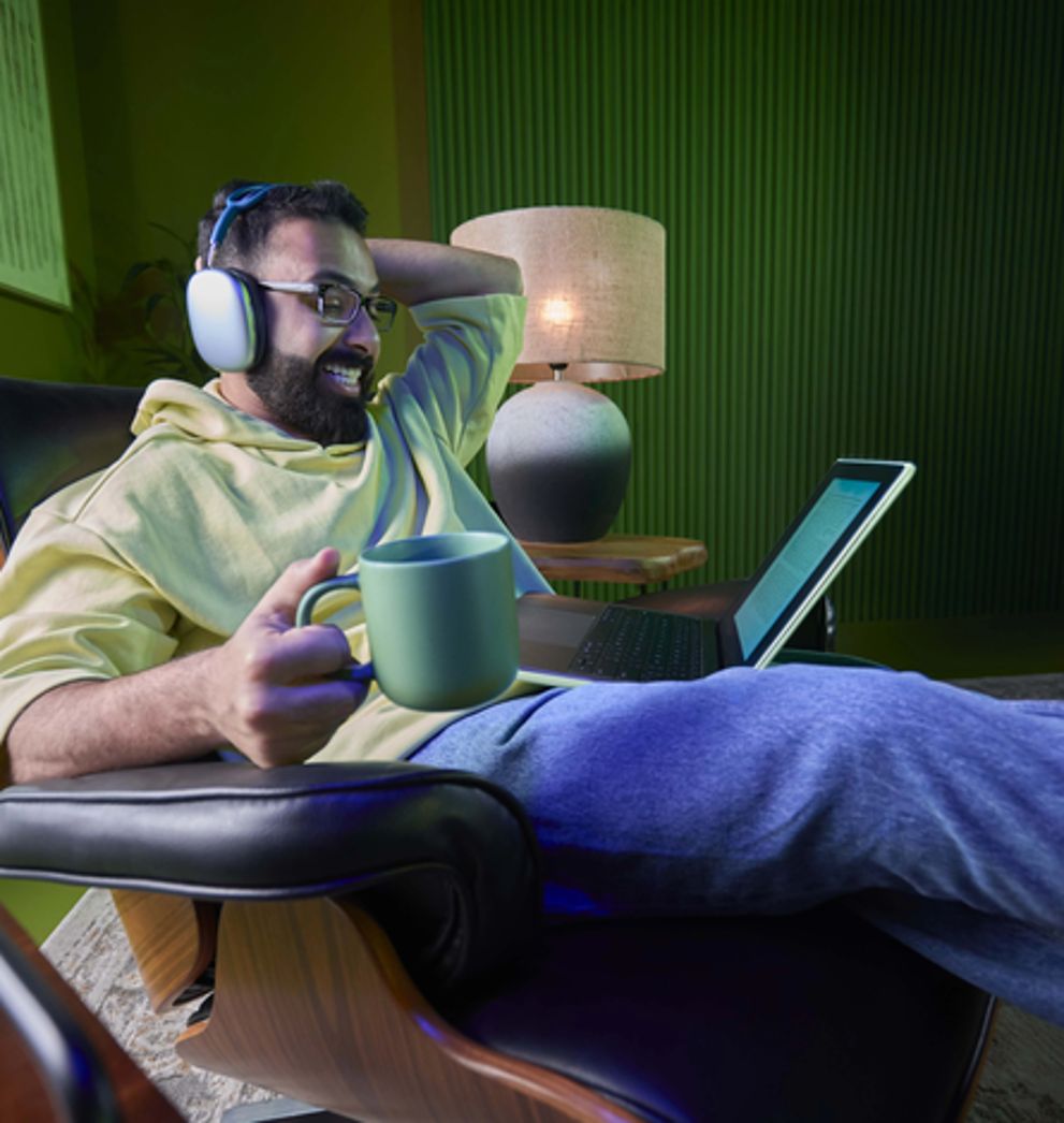 Man having coffee and using a laptop on a Salam roaming data add-on in Saudi Arabia